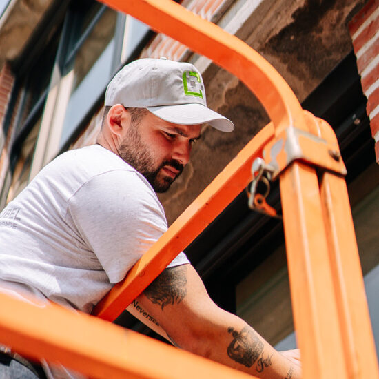 ouvrier Construbel sur une nacelle travaillant sur une façade de bâtiment collectif