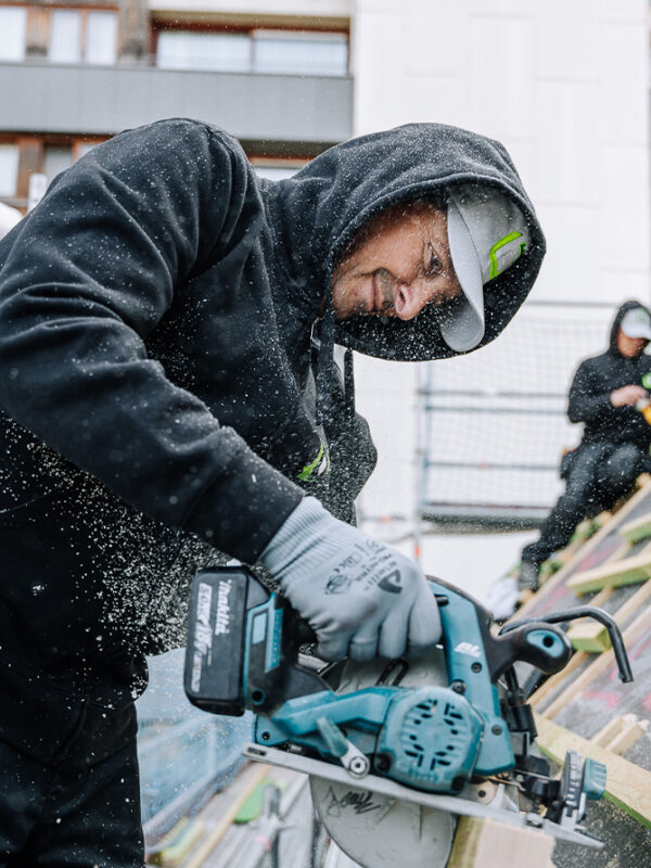 ouvriers travaillant sur une toiture inclinée en ville