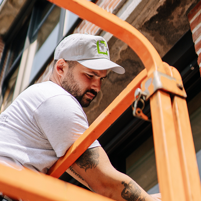 installateur de châssis en bois sur nacelle à l'extérieur d'un bâtiment industriel