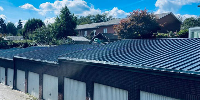 Toiture inclinée - Couverture en profils métalliques (Acier galvanisé) Rangée de garages dont les toitures en profils métalliques ont été rénovés