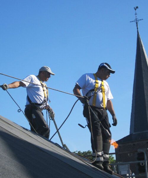 2 ouvriers sur un toit incliné sécurisé par une corde