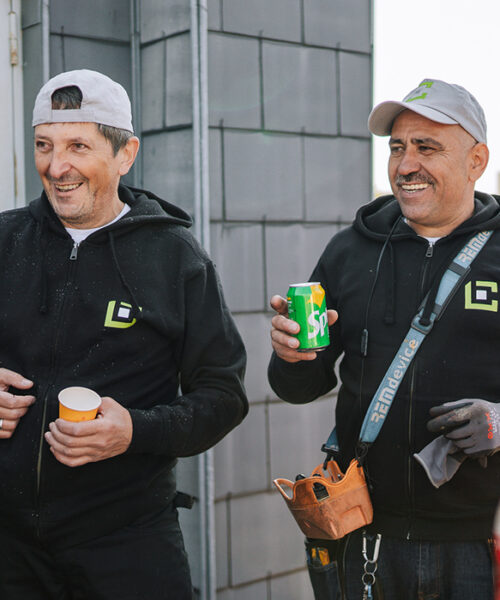 Deux ouvriers qui rigolent en buvant un soda lors d'une pause