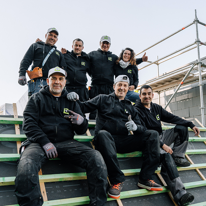 Notre mission, notre vision et nos belles valeurs comptent pour vous ? Equipe de 7 ouvriers qui posent pour la photo sur un toit de bâtiment public en chantier